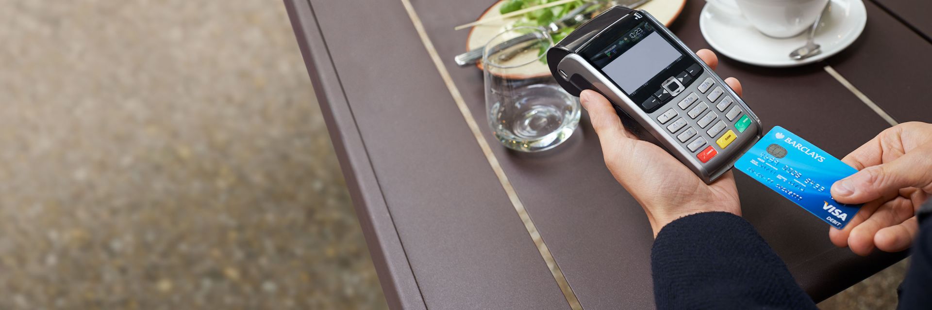 A Barclays Visa Debit card being inserted into a card reader at a restaurant